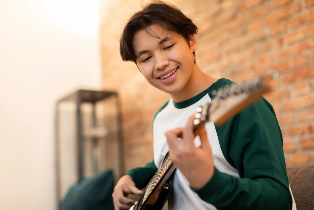 Student learning electric guitar during beginner guitar classes in Singapore, practising chords and building confidence with guided instruction.